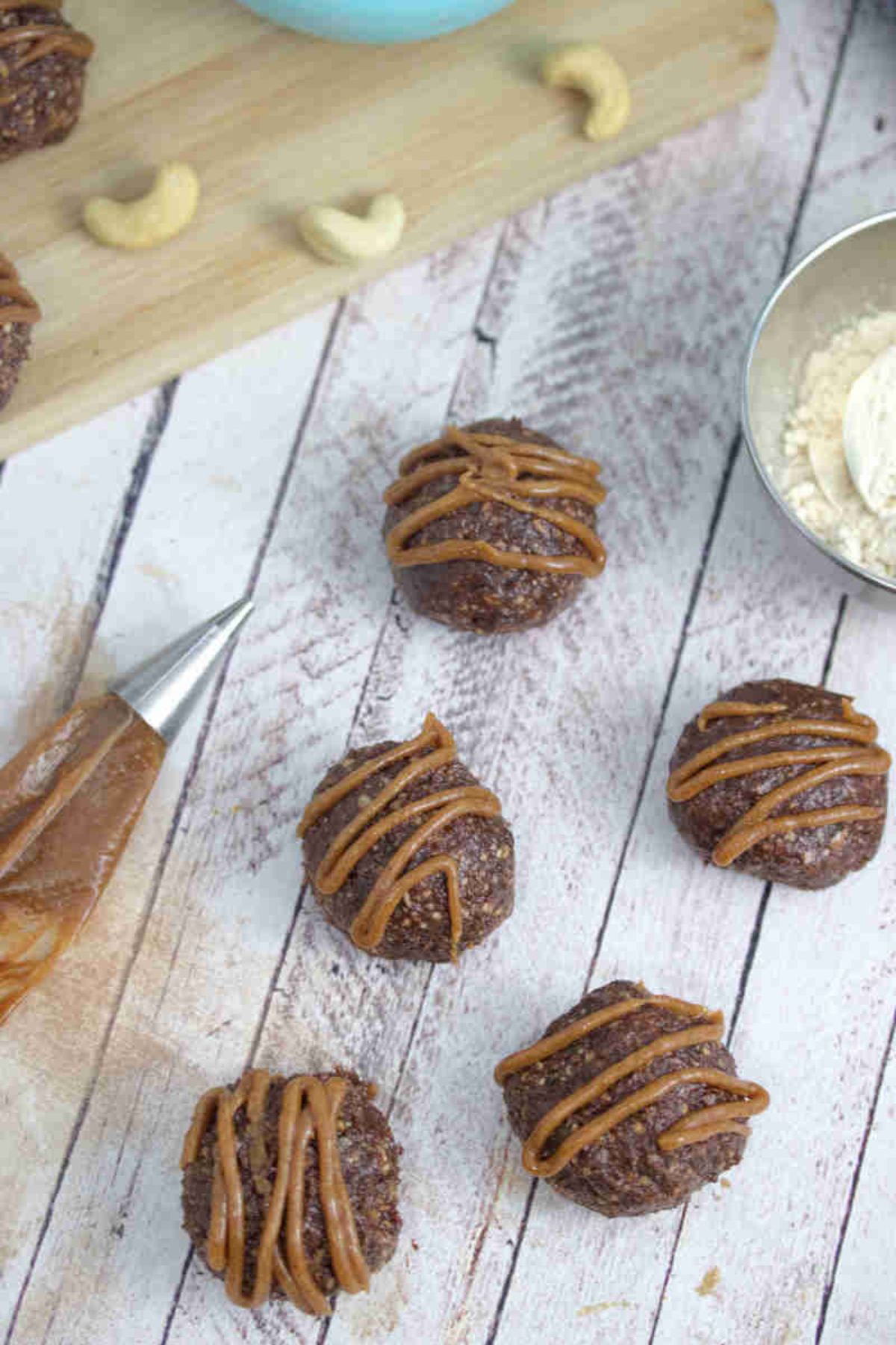 Chocolate balls with dairy-free caramel sauce piped onto them.