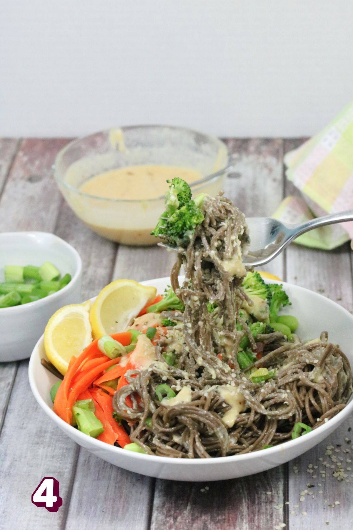 Soba noodle bowl with veggies and a fork being pulled out.