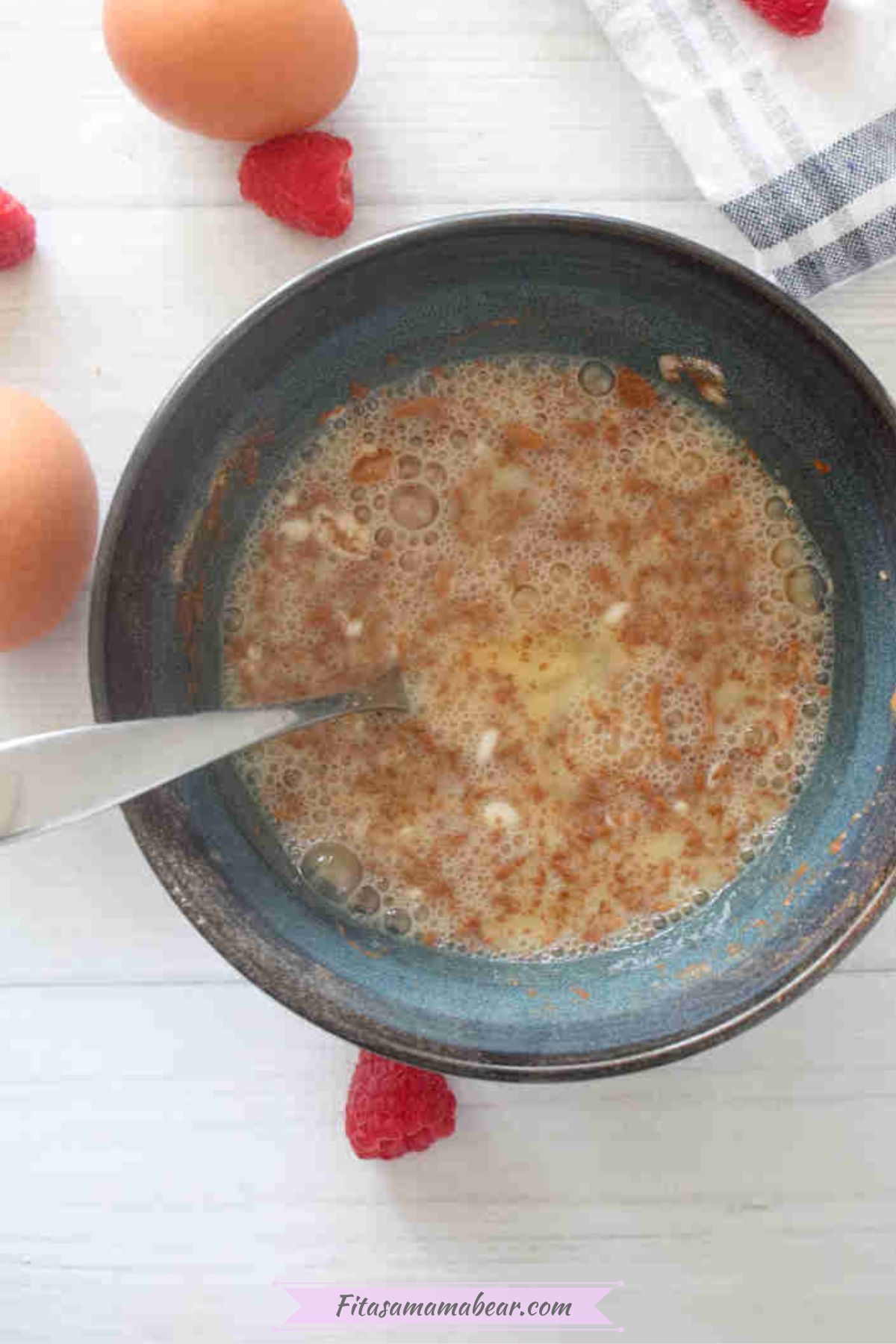 Raw egg white pancake with cinnamon in a blue bowl with a fork.