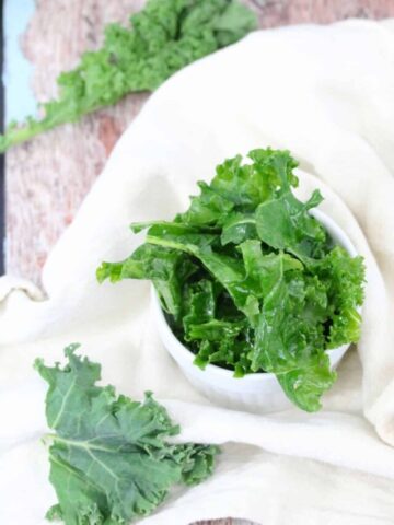 Kale prepared in a white ramekin with more kale around it.