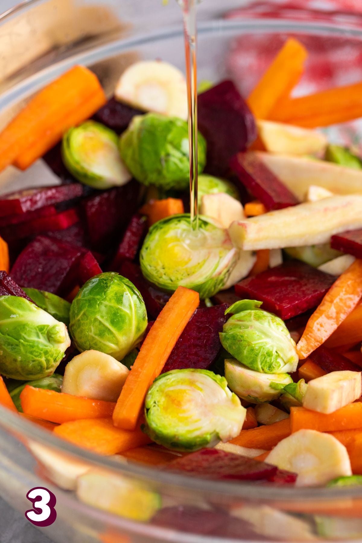 Brussels, carrots, turnips, and beets in a glass bowl.