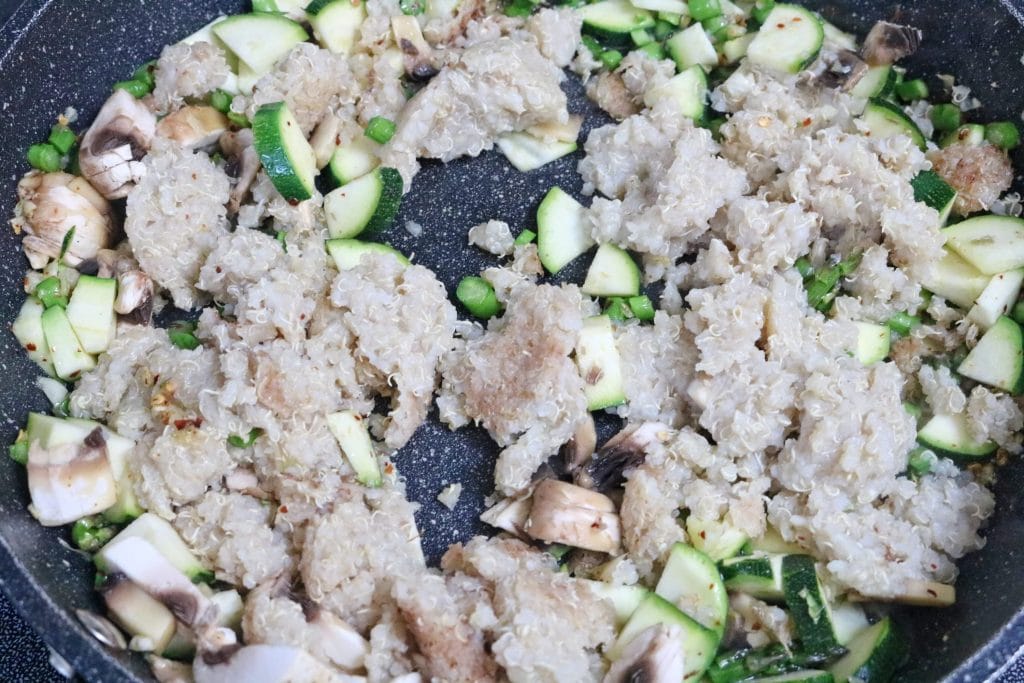 Quinoa, zucchini, mushrooms and garlic cooking in a pan