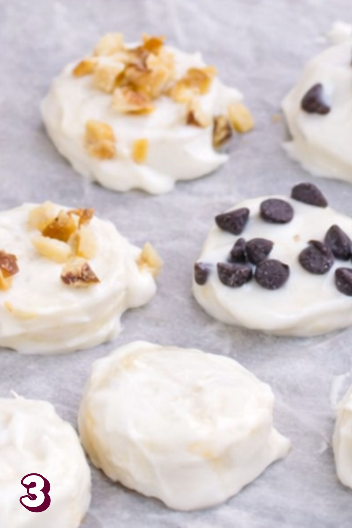 Bananas covered in yogurt with walnuts and chocolate chips on top.