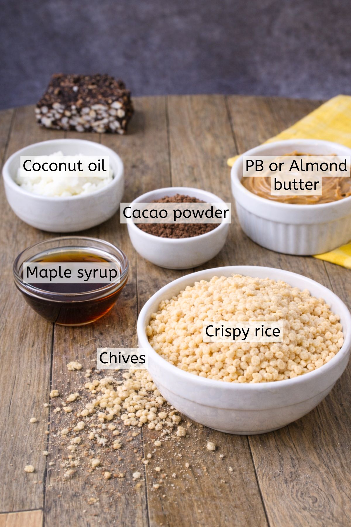Crispy rice, cacao powder, maple syrup, peanut butter, and coconut oil in bowls with text labels over top.