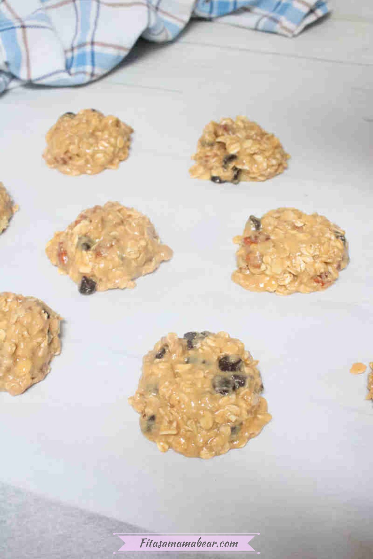 Cashew cookies with chocolate chips uncooked on parchment paper.