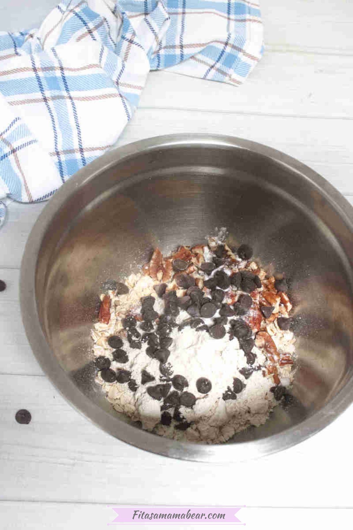 Steel bowl with oat flour, pecans, and chocolate chips in it.