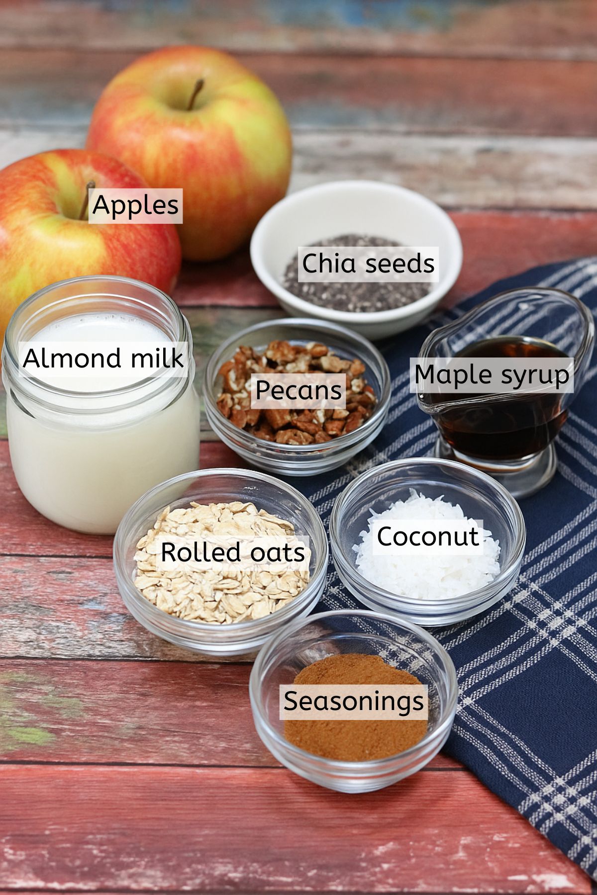 Ingredients like oats, chia seeds, maple syrup, and more in cups with text labels over top.
