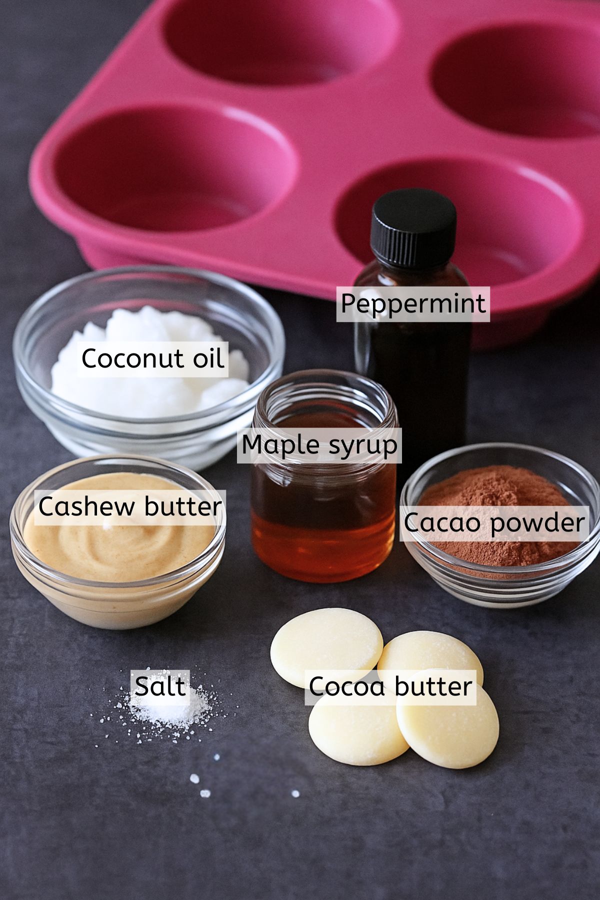 Multiple ingredients like coconut oil, cocoa butter, and maple syrup in jars with text labels over top.