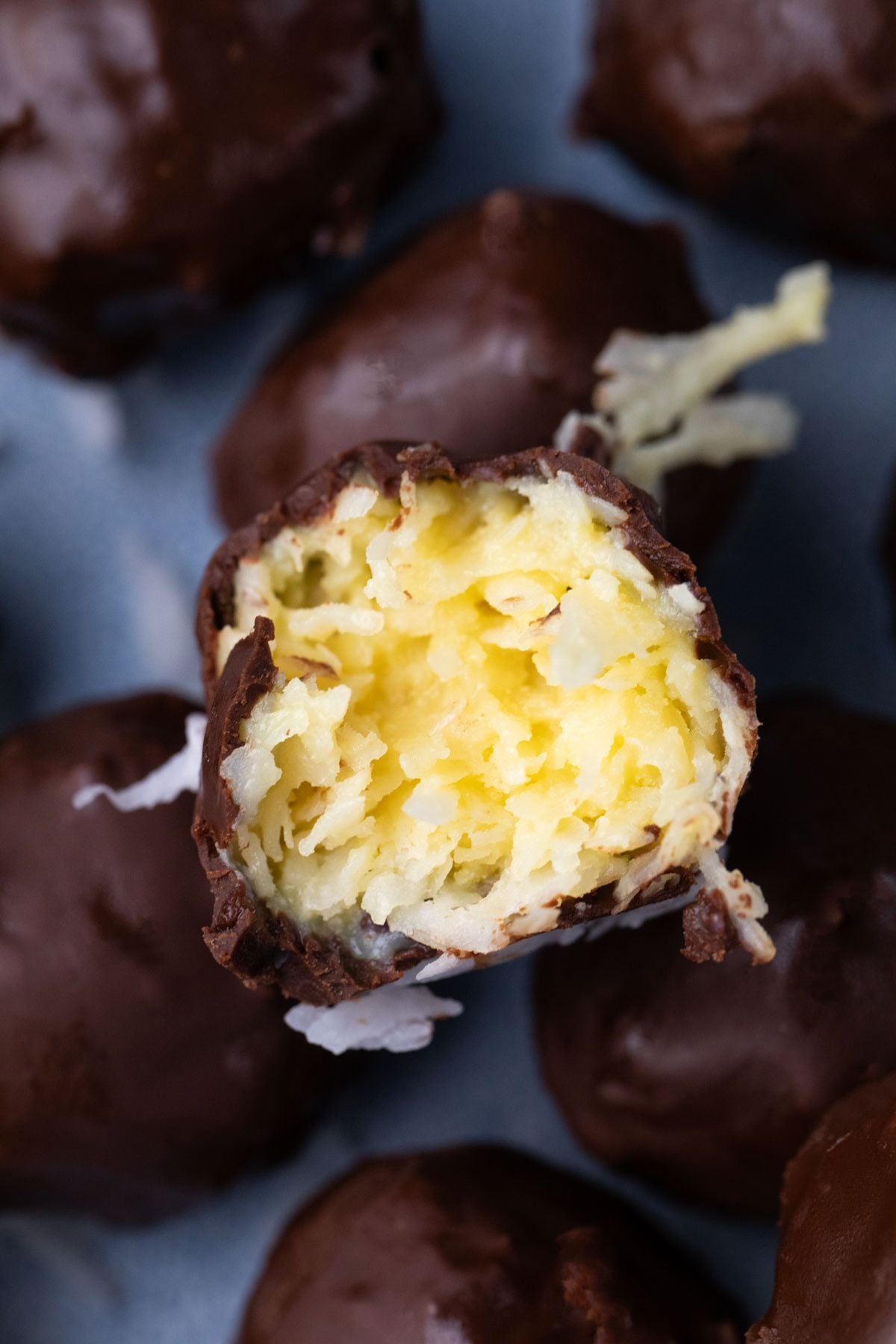 Chocolate coated coconut protein balls with a bite out of it.