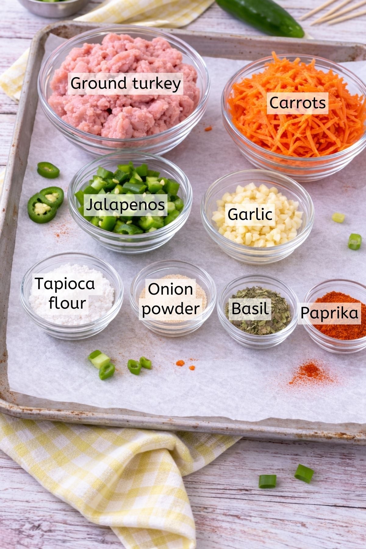 Ground turkey, seasonings, and flour to make meatballs in glass bowls with text labels over top.