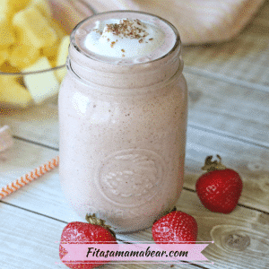 Featured image: a pink smoothie in a mason jar surrounded by whole strawberries