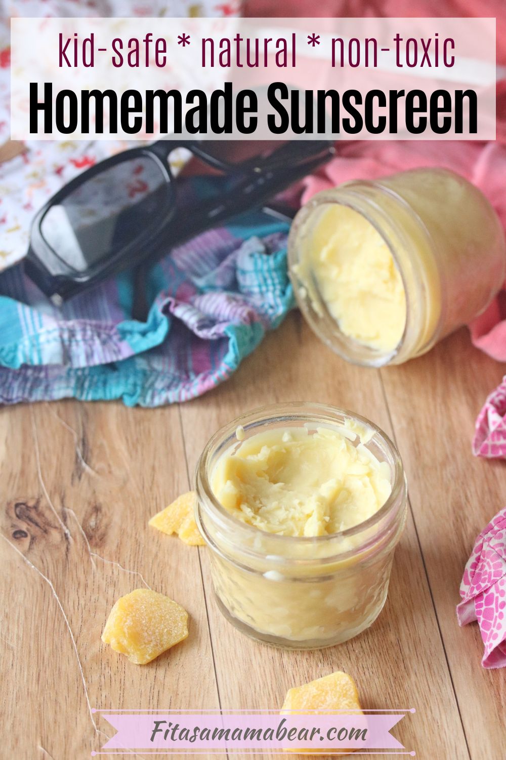 Pinterest image with text: two mason jars with homemade sunscreen surrounded by summertime clothes.