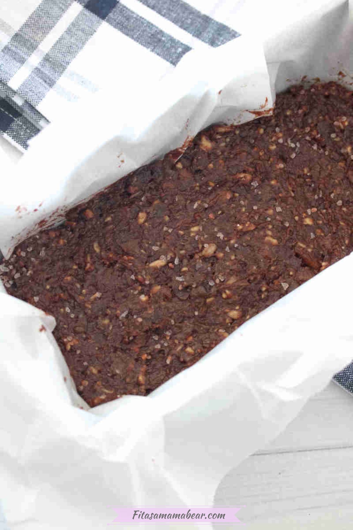 Chocolate date protein bars in a loaf pan lined with parchment paper.