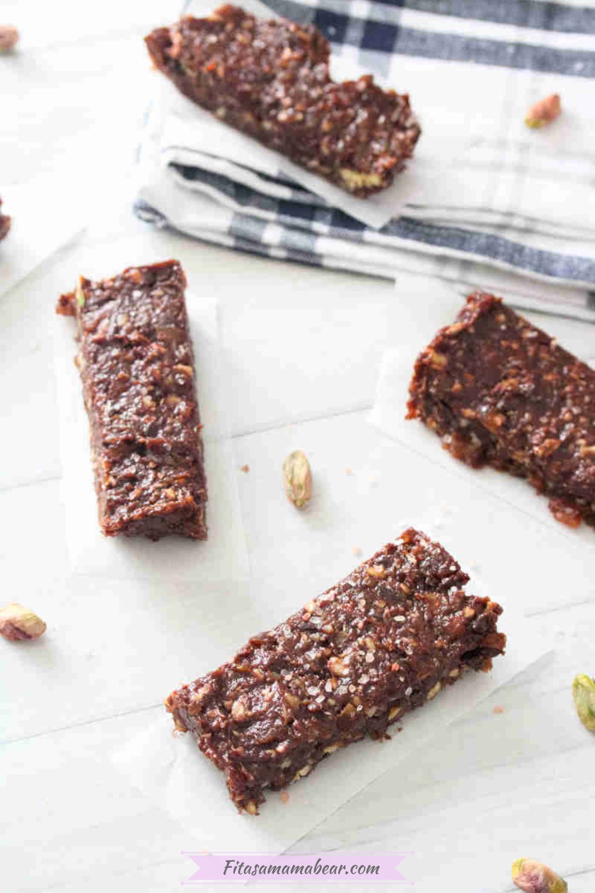 Mint chocolate protein bars on parchment paper with nuts around them.