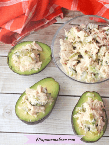 Pin image with text: Sliced avocados stuffed with tuna salad around a glass bowl of tuna salad