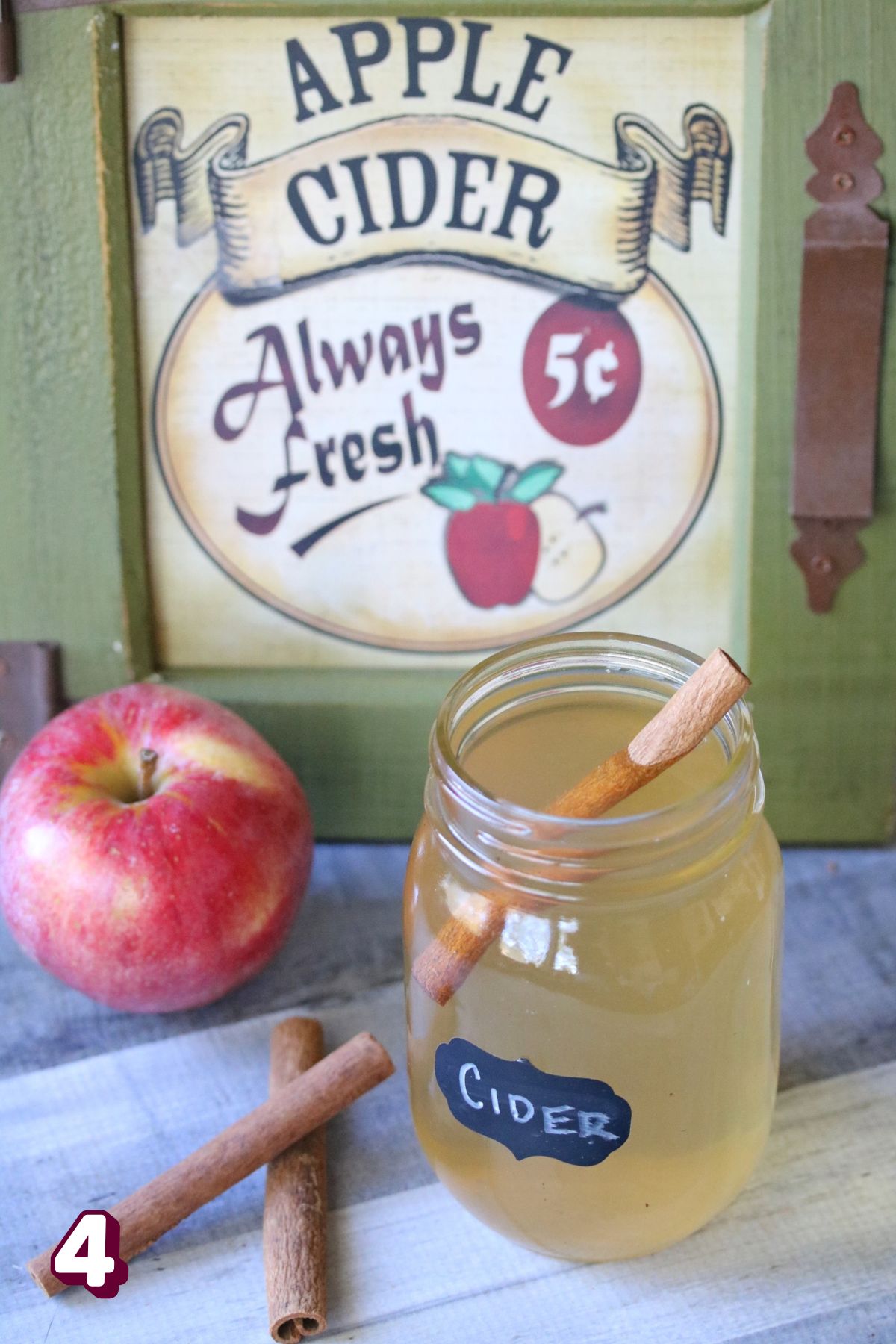 Old fashioned apple cider in a mason jar with a cinnamon stick.