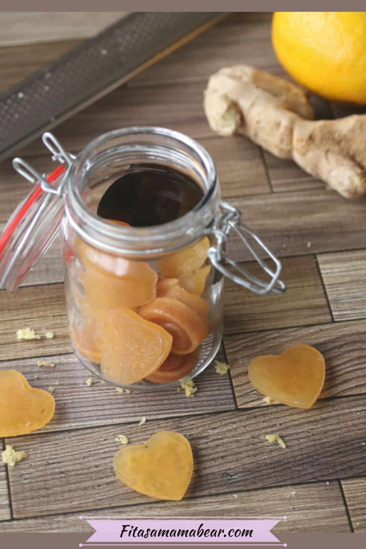 Three heart shaped honey cough drops around a mason jar filled with cough drops with lemon and ginger behind it