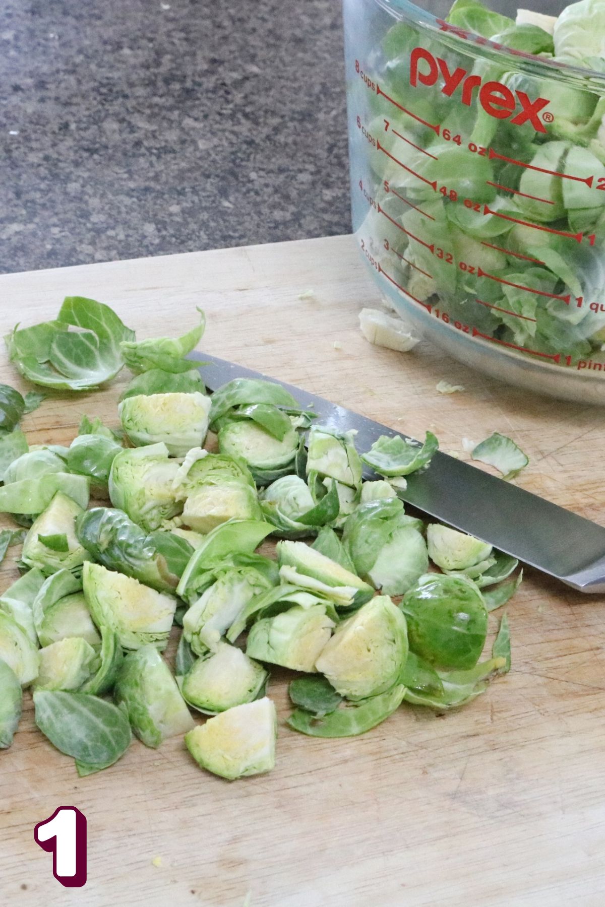 Brussels sprouts on a cutting board being chopped.