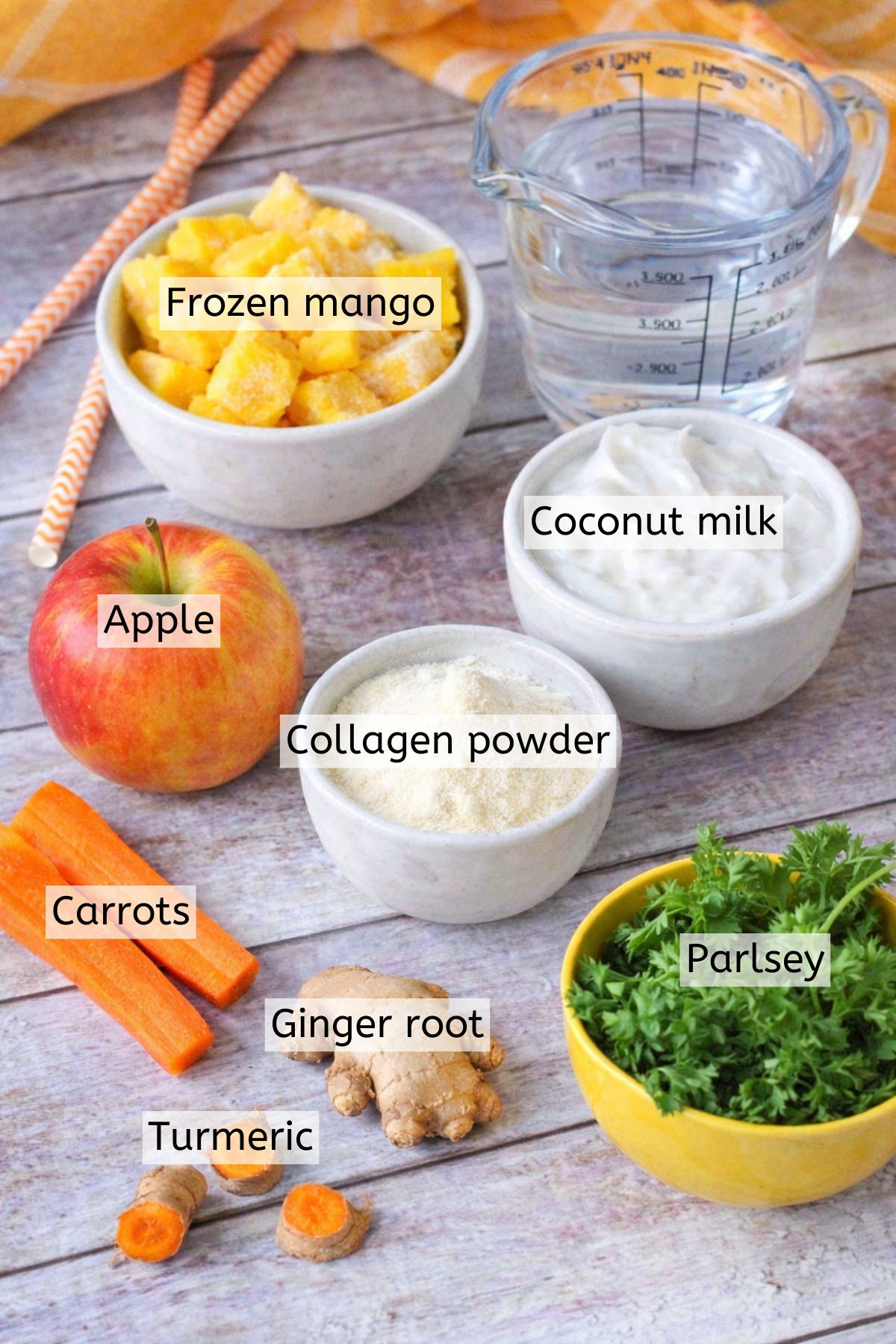 Carrots, coconut milk, parsley, frozen mango and more in bowls with text labels over top.