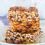 Honey drizzled onto rice crispy squares with chocolate chips in them.
