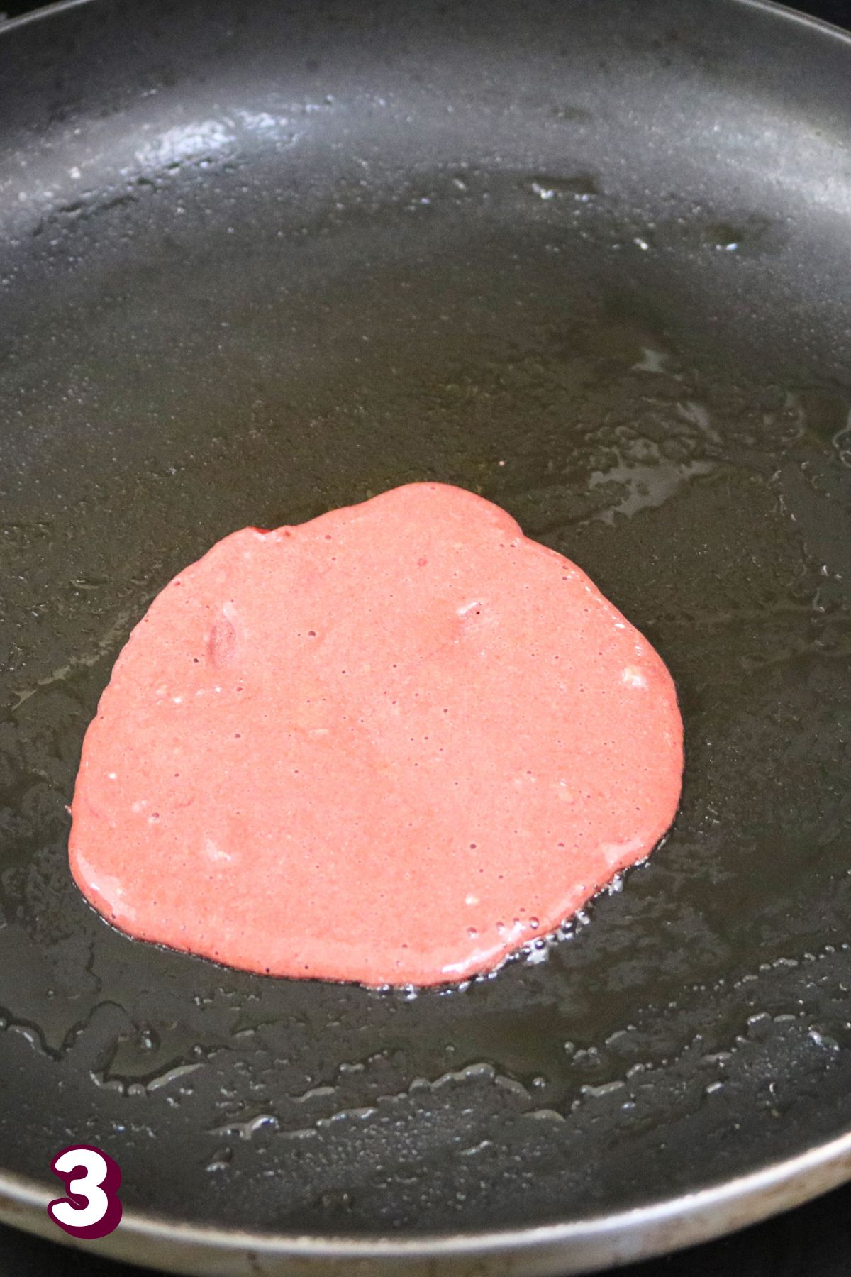 Pink crepe in a frying pan.