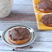 paleo cookies topped with chocolate frosting with a mug on the side