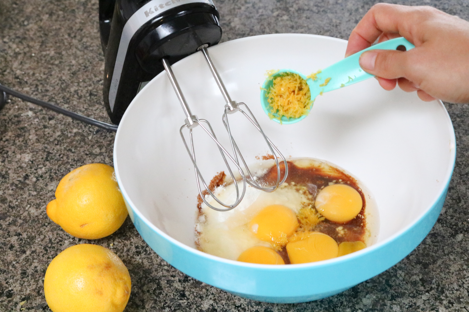 In process image for lemon bars: lemon being added to eggs before mixing