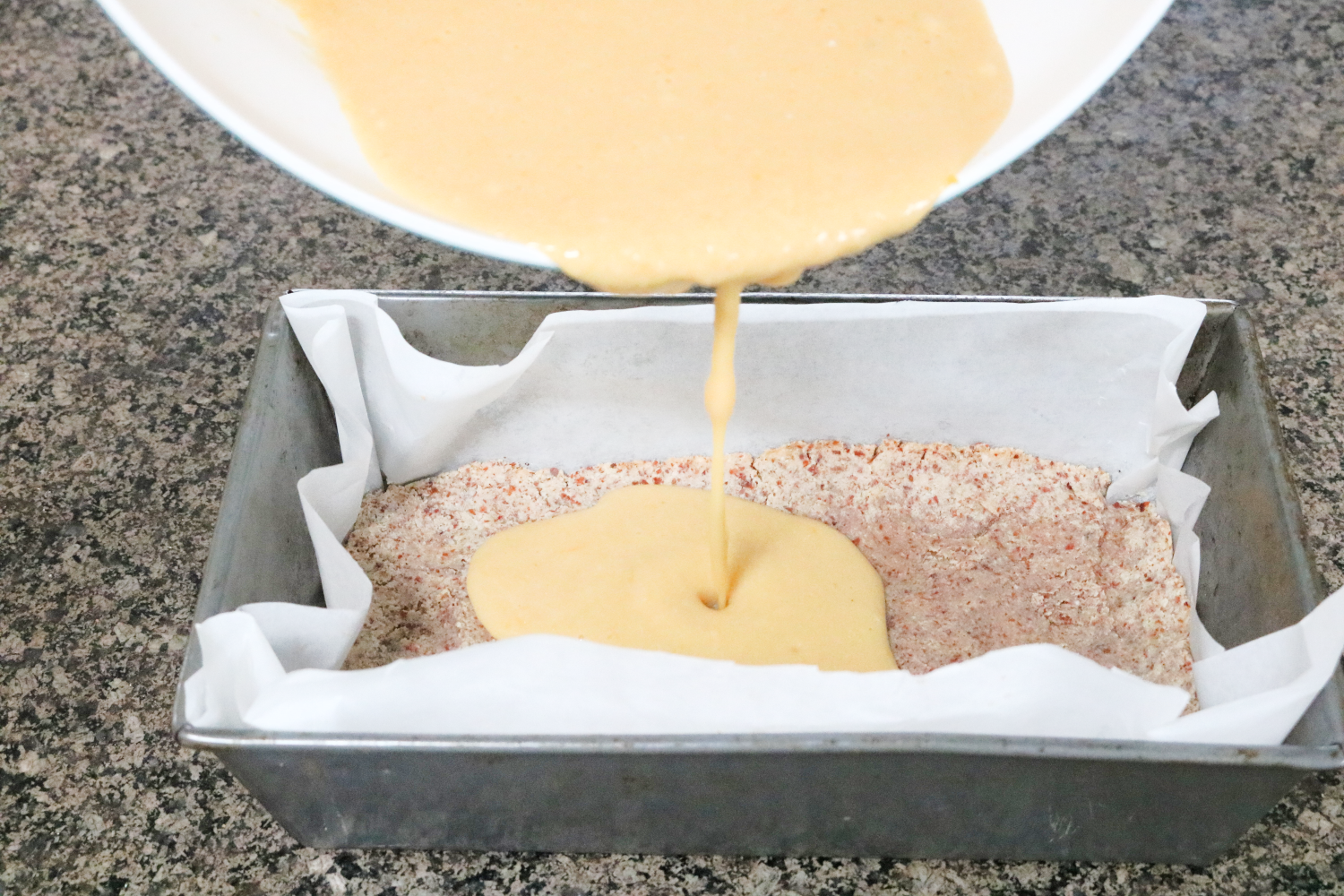 In process image for lemon bars: lemon mixture being added to crust in pan