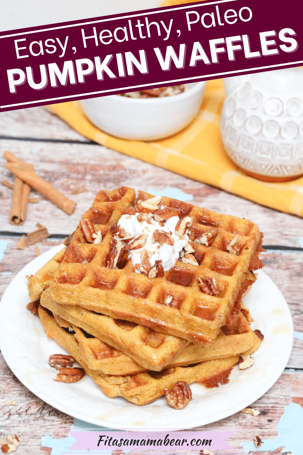 Pinterest image with text: three paleo pumpkin waffles stacked on a white plate with syrup and coconut milk. Pecans and syrup in white dishes on a yellow cloth behind them.