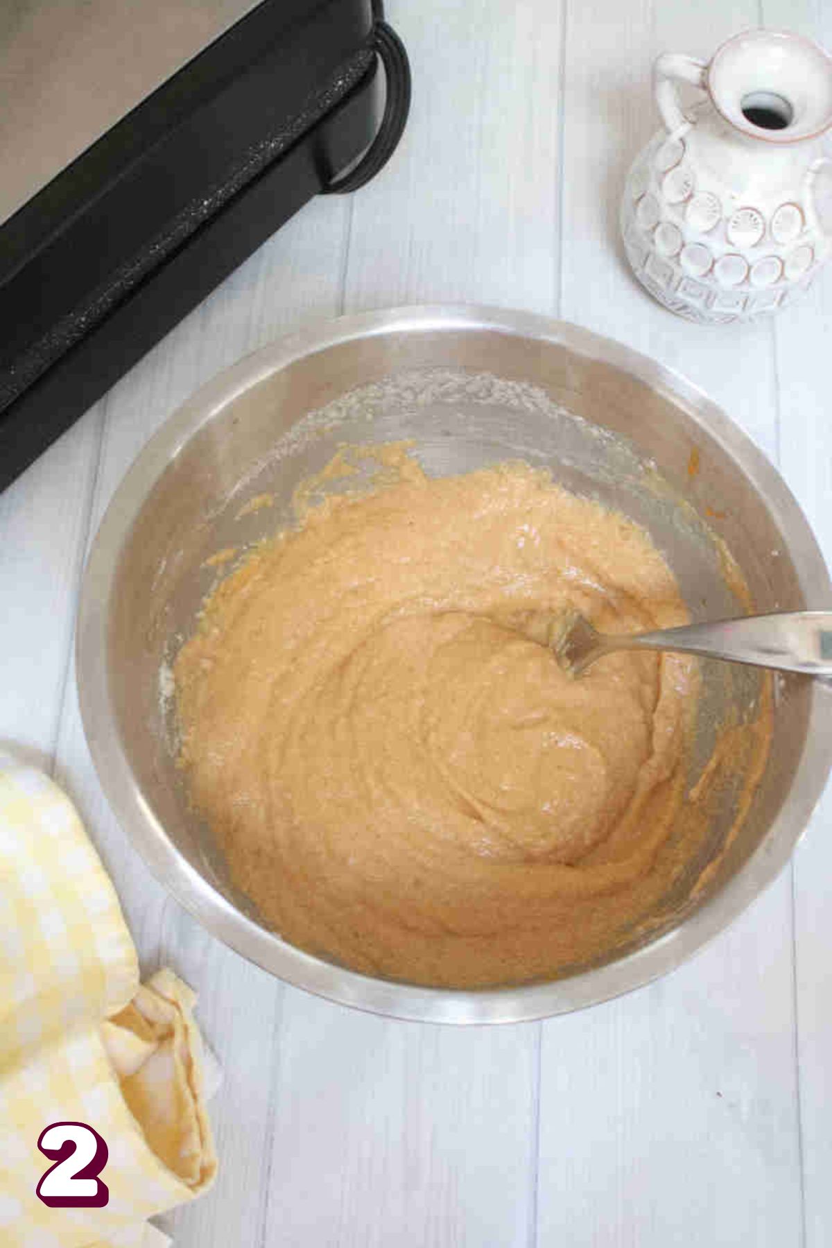 Steel bowl with pumpkin waffle batter in it.