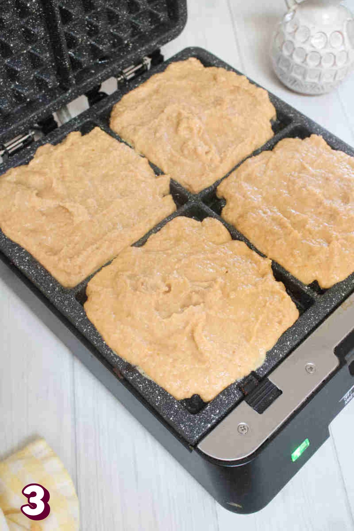 Raw pumpkin waffles in a cast iron waffle machine.