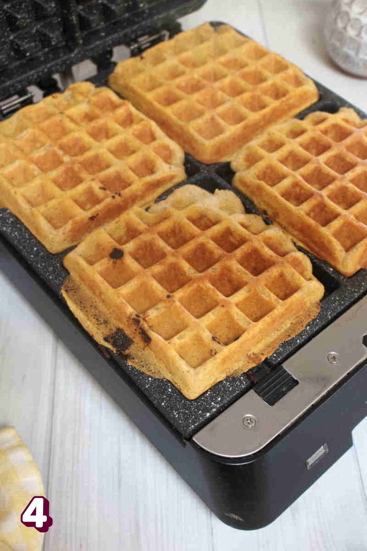 Golden pumpkin waffles in a casti iron waffle maker.