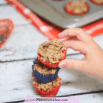 Featured image with text: three bite-sized toddler muffins stacked on top of each other with a toddlers hand reaching for them andwith chia seeds and a white ramekin with more muffins behind them