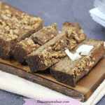 Featured image: sugar-free banana bread cut in slices on a cutting board with one slice topped with dairy-free butter