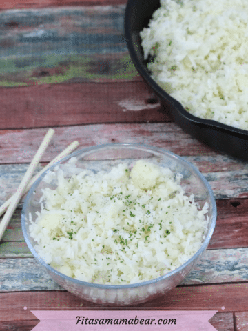 Featured image with text: glass bowl with vegan cauliflower rice and chopsticks on the side with more cauliflower rice in a pan with a wooden spoon behind it