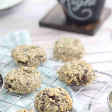 Nut-free breakfast cookies on a cooling rack on a blue linen with plates and chocolate chips around them.