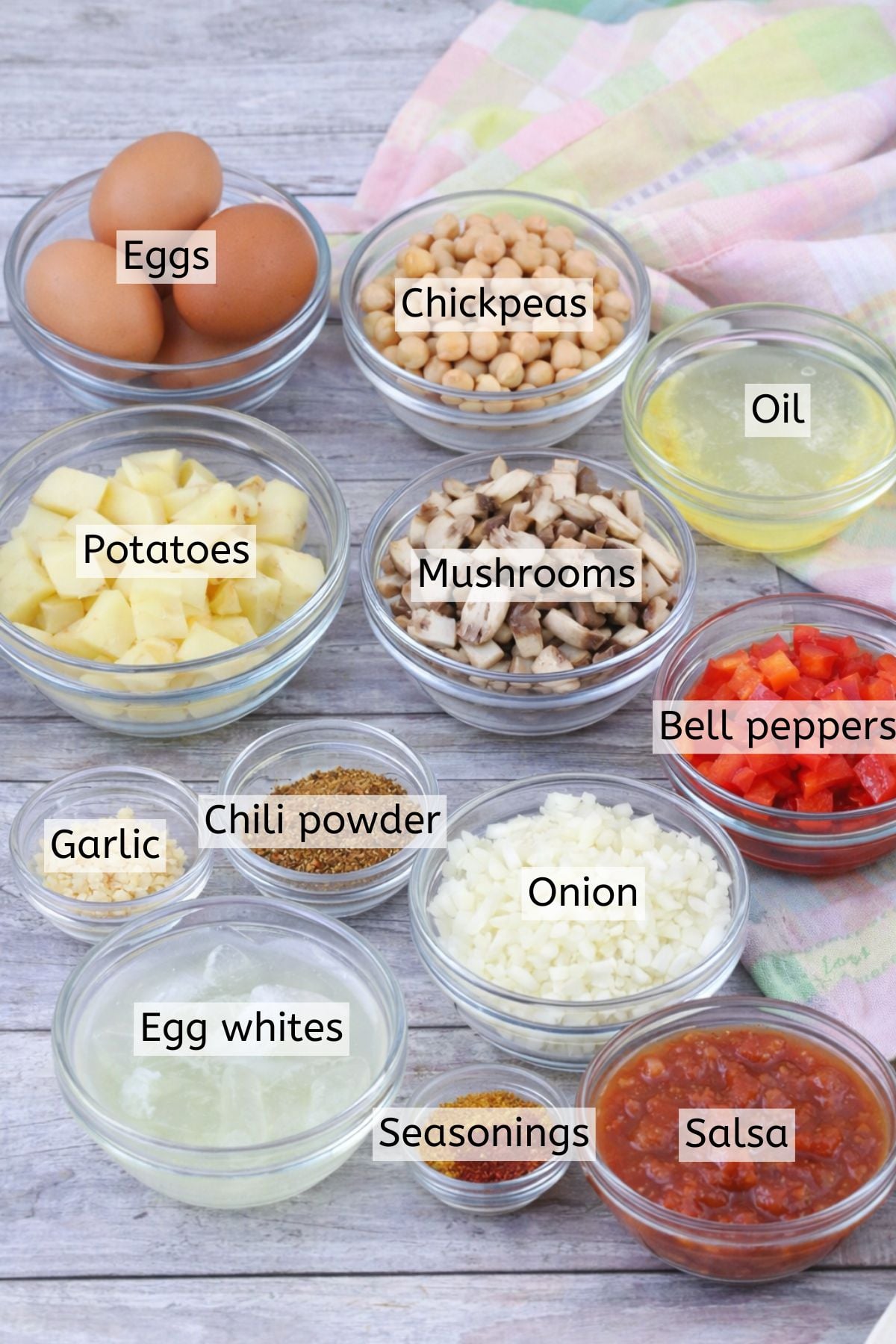 Ingredients to make breakfast has in glass bowls with text labels over top.