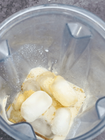 Blender with frozen bananas, ice cubes and bone broth powder