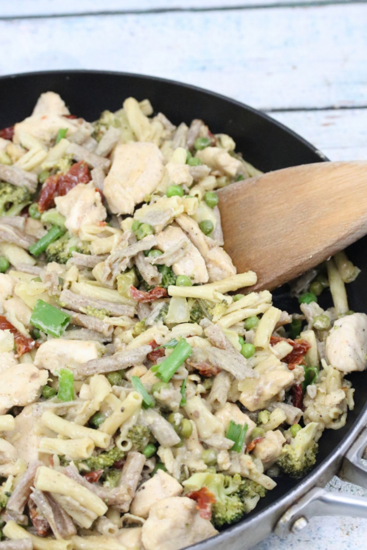Cast iron pan with noodles, chicken, broccoli and sundried tomatoes in a creamy alfredo sauce.