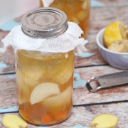 Fire Cider in a Jar with a lid on a distressed wood table.