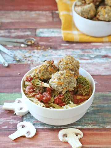 Healthy meatballs on top of tomatoes and spaghetti squash in a white bowl