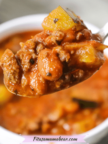 Featured image: white bowl of venison chili with a spoon of chili lifting out