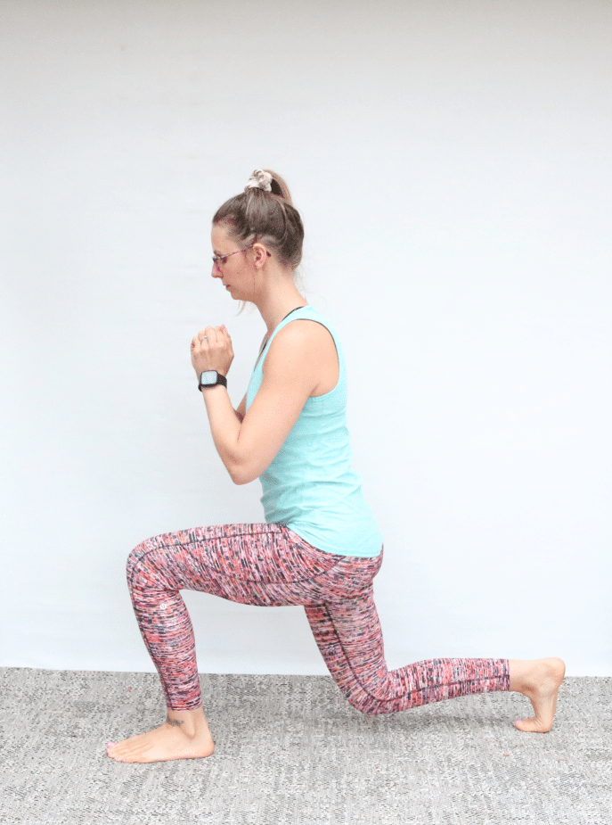 Woman in blue tank top and orange pants performing a bodyweight lunge