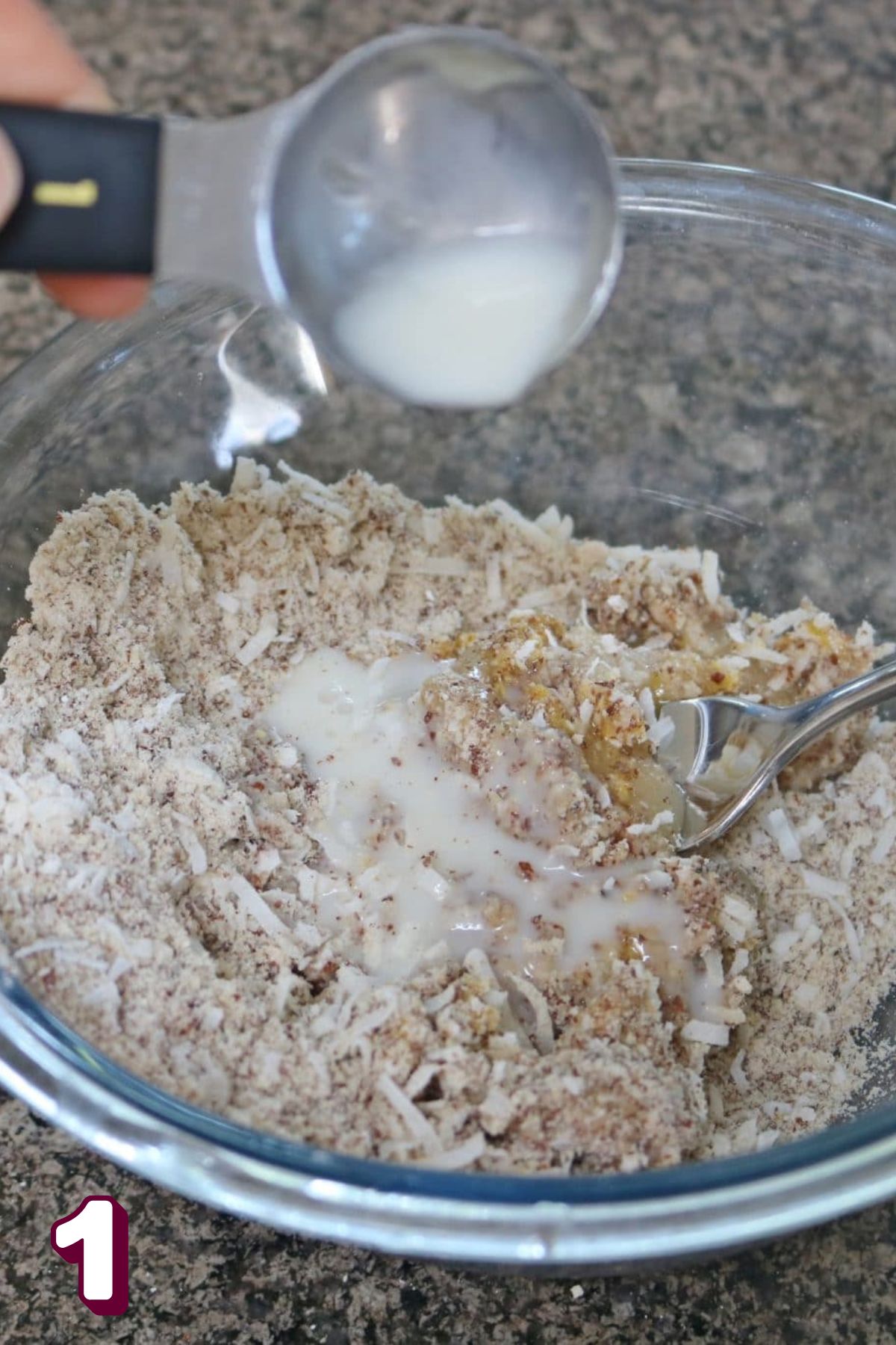 Almond milk being poured into a glass bowl with almond flour and coconut.