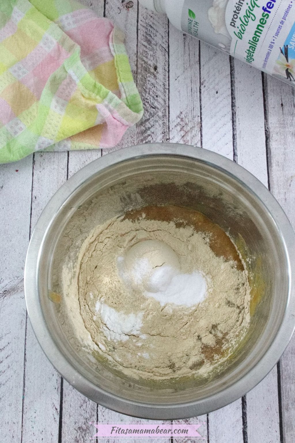 Protein powder and baking powder in a steel bowl with raw eggs and a linen behind it