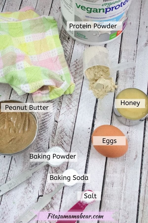 Multiple ingredients like eggs, honey, peanut butter and protein in measuring cups and spoons with text labels
