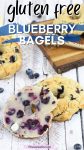 Pin image with text: A blueberry bagel cut in half and openfaced smeared with butter with another bagel behind it and more on a dark cutting board with a stick of honey