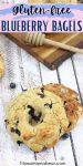 Pin image with text: A gluten-free blueberry bagel cut in half and stacked with another bagel on a yellow linen and more on a cutting board with a honey stick behind them