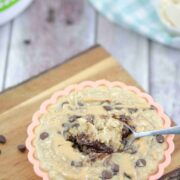 orange solicone mold on a cutting board with peanut butter chocolate chip baked oatmeal with a spoonful coming out and a blue linen behind it