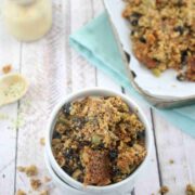 two white ramekins stacked and the top one full of nut-free granola with more granola around the bowls and on a baking tray behind them